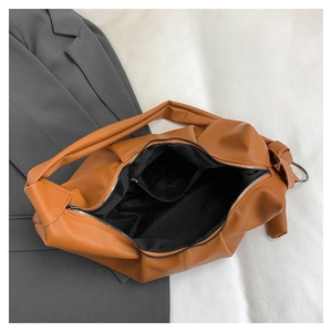 Detail of brown PU leather tote showing interior fabric lining and metal zipper closure