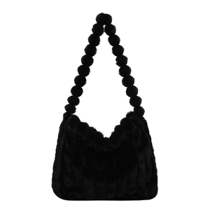 Large black plush tote bag with vertical stripes and fuzzy ball handle for winter