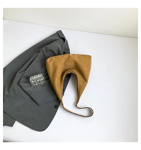 Vista dall'alto di una borsa hobo in pelle scamosciata zenzero su una giacca grigia