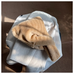 Detail of plush camel faux fur scarf with soft texture and warm criss-cross design
