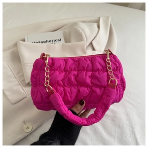 Detail of bright pink pleated cloud bag with chunky gold chain and quilted fabric texture
