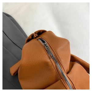 Detail of lychee pattern brown leather texture and smooth metal zipper on dumpling bag