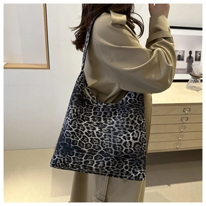 Lifestyle shot of large leopard print tote bag styled with a beige trench coat