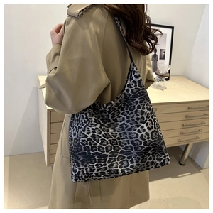 Leopard print tote bag styled with a long khaki trench coat in a cozy minimalist room