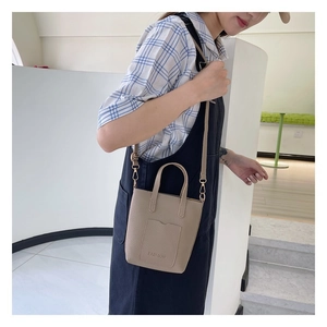 Detail of khaki pebbled leather crossbody bag with Fashion embossing and carry handle