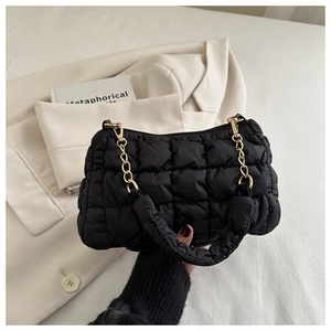 Detail of black quilted cloud bag showing plush texture and gold chain strap