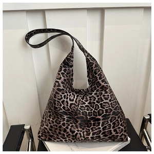 Detail of trendy leopard print tote bag with wide strap on a modern chair