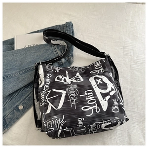 Detail of high-capacity canvas bag with black and white graffiti print and adjustable strap