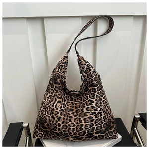Close-up of a large leopard print tote bag placed on a minimalist chair for a casual look