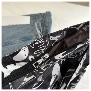 Detail shot of smooth black and white graffiti tote bag featuring a high quality metal zipper