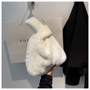 Detail of soft white faux fur handbag with a unique single knot handle design