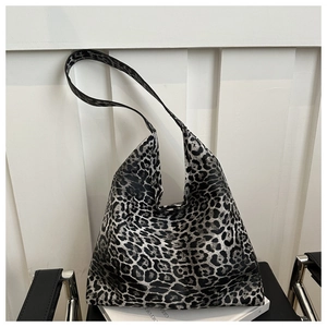 Close-up of leopard print tote bag with wide strap on books for casual fashion style
