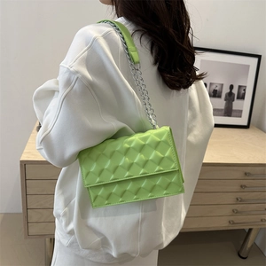 Fluorescent green quilted crossbody bag with silver chain strap on a white hoodie
