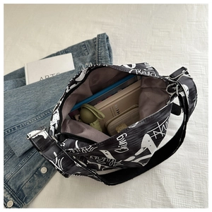 Interior view of large canvas crossbody bag with shark print showing daily essentials space