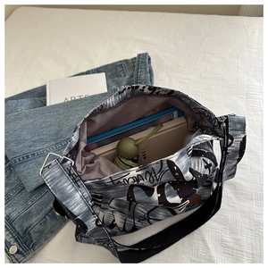 Detail of spacious denim print canvas bag showing internal storage for books and umbrella