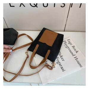 Detailed macro view of the two-tone minimalist bag with FASHION embossed leather and gold hardware