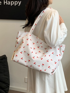 Détail du sac cabas en toile blanche avec imprimé cerise rouge et grande poignée