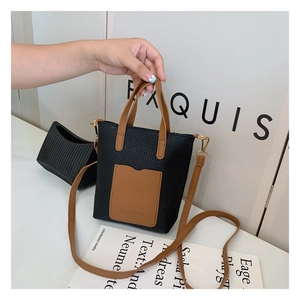 Detail of a mini two-tone crossbody bag with black lychee leather and fashion stamp