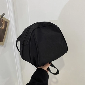 Detailed close-up of a black nylon crossbody bag with smooth zipper and durable webbing handle