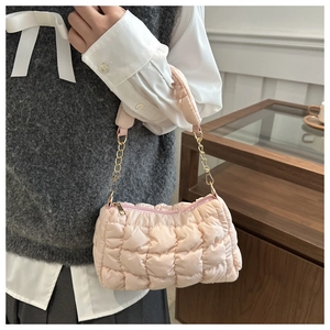 Detail showing pink quilted fabric texture and gold chain strap of a casual shoulder bag