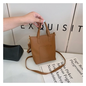 Close-up of caramel lychee grain leather mini tote with FASHION lettering and gold hardware