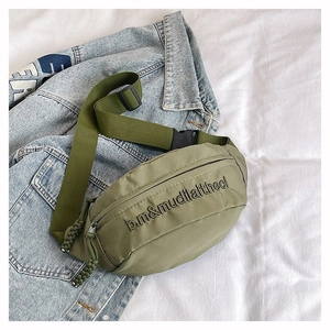 Vue macro détaillée du sac banane en nylon vert olive avec texte embossé et tirette tissée