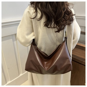 Detail of adjustable wide shoulder strap on a large chocolate brown tote bag