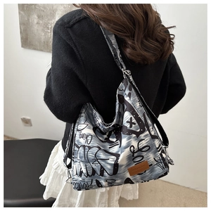 Detail of grey canvas tote bag featuring street style graffiti prints and adjustable strap