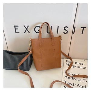 Close-up of brown litchi pattern leather handbag with fashion embossed front pocket