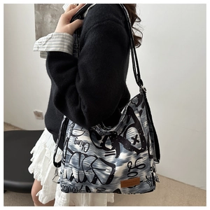Detail view of durable canvas shoulder bag with black and white graffiti print patterns