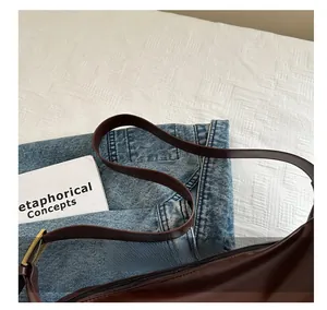 Detailed close-up of dark brown leather shoulder bag with smooth matte finish and zipper