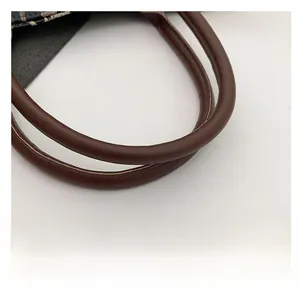 Detailed view of the brown leather shoulder strap with fine stitching on leopard tote bag
