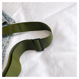 Détail de la bandoulière en nylon vert armée avec boucle réglable en plastique noir
