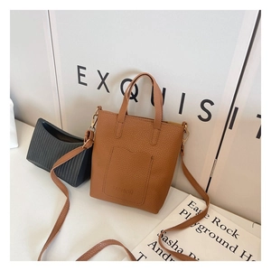 Detail of brown lychee grain PU handbag with embossed FASHION text and long strap