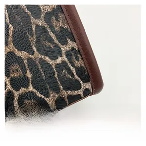 Macro shot of leopard print leather texture with premium brown stitching and edge detail