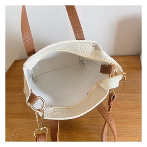 Top view of white pebble leather bag with brown handles and gold metal hardware