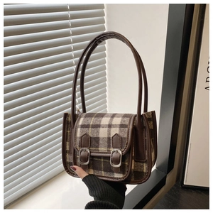 Dettaglio della borsa vintage in lana a quadri con fibbie in pelle e trama