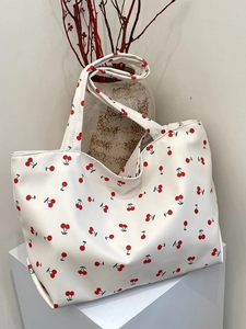 Gros plan d'un grand sac cabas avec imprimé cerises rouges sur toile blanc cassé