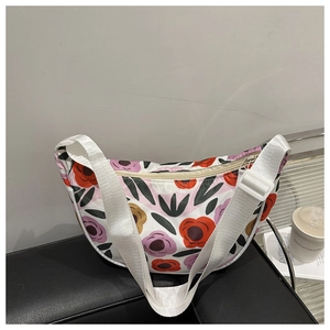 Dettaglio della borsa sottobraccio a fiori con motivi rossi e viola e tracolla reg.