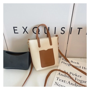 Detail view of cream white and brown crossbody bag with lychee grain leather texture