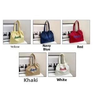 Detail view of large nylon tote bags in yellow, navy, red, khaki, and white options