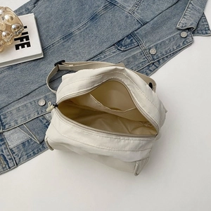 Detailed overhead view of beige canvas crossbody bag interior with inner pocket and zipper
