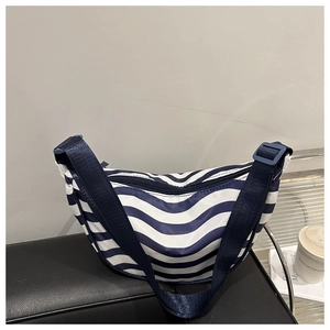 Dettaglio della borsa a tracolla a righe bianche e blu con tracolla regolabile in stile lifestyle