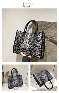 Macro detail of large leopard print tote bag with black leather handles and texture