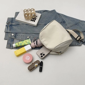 Detail showing high-capacity interior of minimalist canvas messenger bag with lifestyle items