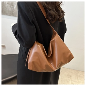Detailed back view of a large brown soft leather tote bag worn on shoulder for commuting