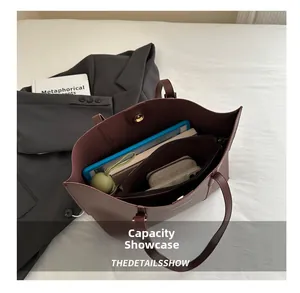Top-down view of large dark brown tote bag interior with multiple items and zipper pocket