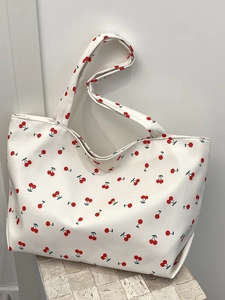 Détail d'un grand sac cabas blanc avec motifs cerises et texture en similicuir souple