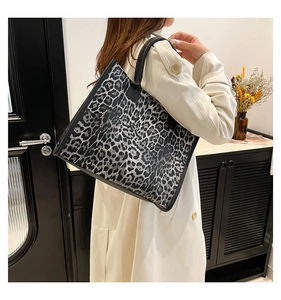 Close-up of leopard print tote bag styled on model in a modern home setting