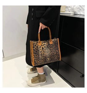 Close-up of leopard print tote bag with brown leather handles and spacious interior